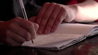 Man writing Notes on a Notebook with a Pen. Close-up. 