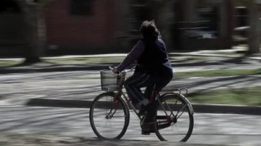 Woman riding Bicycle along the Street in General Madariaga, Buenos Aires province, Argentina.