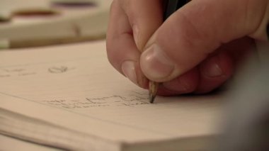 Primary School Student Writing on Notebook using a Pencil. Close Up. 