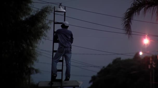 Pracownik Komunalny Zmieniający Żarówkę Lampy Ulicznej Zachodzie Słońca — Wideo stockowe
