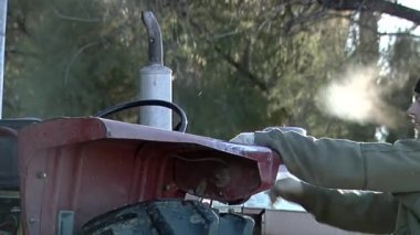 Young Man Driving an Old Tractor in a Rural Field in Argentina.  