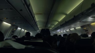 Interior of a Passenger Airplane with Passengers on Seats.