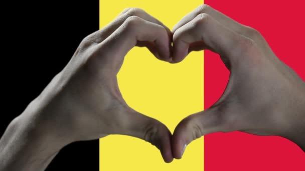 ベルギー国旗とハンドハートシンボル ベルギー国旗に対するハート型を示す手 閉じろ — ストック動画