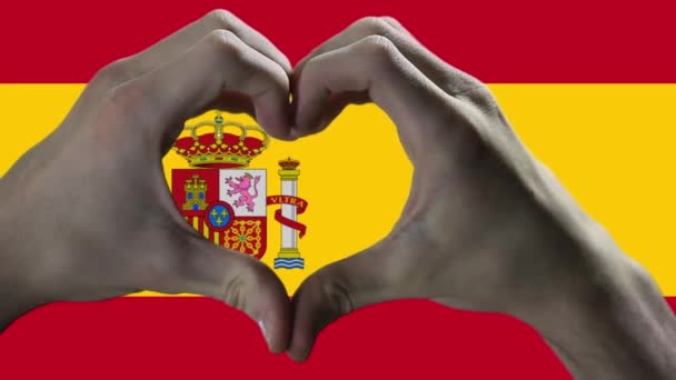 スペインの旗と手のハートシンボル スペインの旗に対してハートの形を示す手 閉じろ — ストック動画