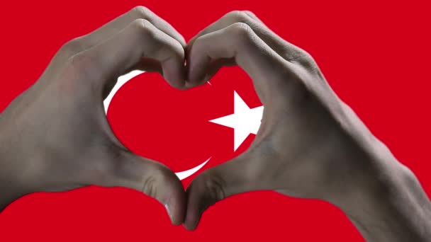 トルコの国旗と手のハートのシンボル トルコの国旗に対するハートの形をした手 閉じろ — ストック動画