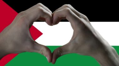 Hands showing Heart Sign over Palestine Flag. 
