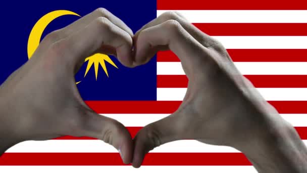 在马来西亚国旗上显示心迹的手 — 图库视频影像
