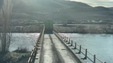 Arjantin 'in Neuquen Eyaleti, Patagonya' da eski bir köprüyü geçen bir kamyon. 4K Çözünürlüğü.