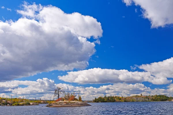 Hoge wolken boven het blauwe water in de herfst — Stockfoto