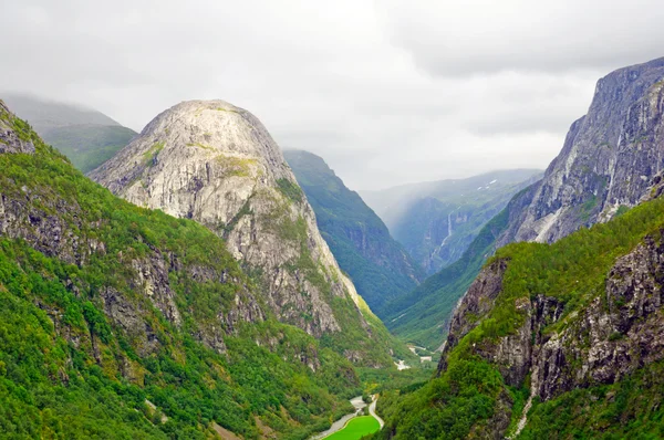 Bald mountain in a verdant valley — Stock Photo, Image