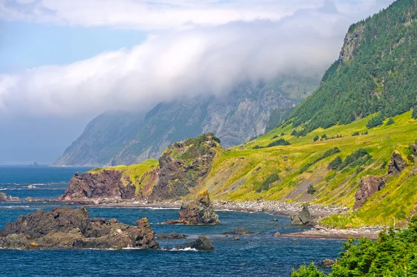 Moln och klippor längs en havet kusten — Stockfoto