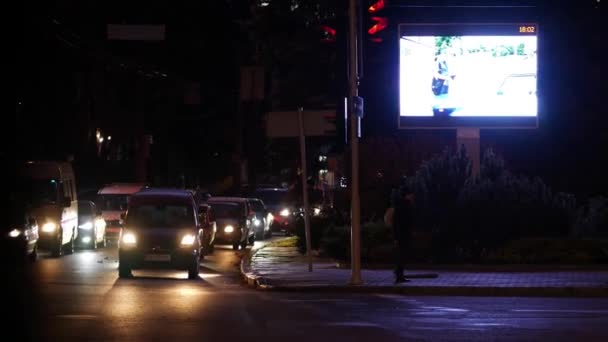 Ecrã LED brilhante enorme com publicidade em vídeo perto de semáforos na avenida. — Vídeo de Stock