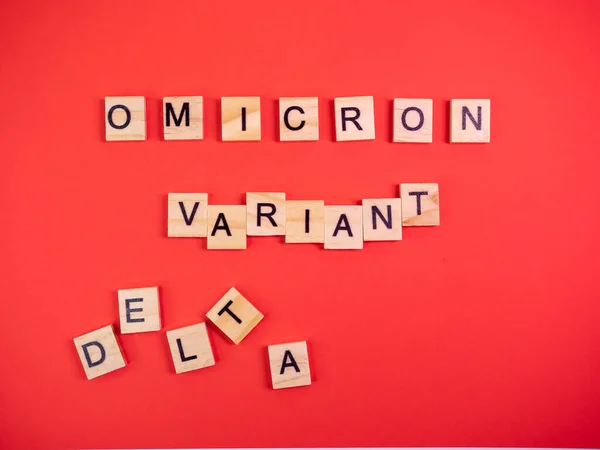 オミクロン多様体はデルタを置き換える コロナウイルスCovid Omicronの新しい危険な株の出現 単語オミクロン変異体デルタ上の色赤の背景 ロイヤリティフリーのストック画像