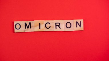 Omicron varyantı Delta 'nın yerini alır. Koronavirüsün yeni tehlikeli bir türü olan COVID-19 Omicron ortaya çıktı. Renkli kırmızı arkaplanda omikron sözcükleri