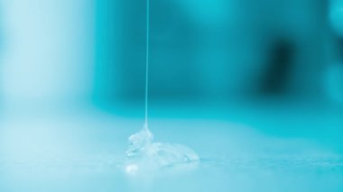 Kalın sıvı yapıştırıcı yavaşça yukarıdan ince akıntıya dökülür ve yüzeyde yayılır.