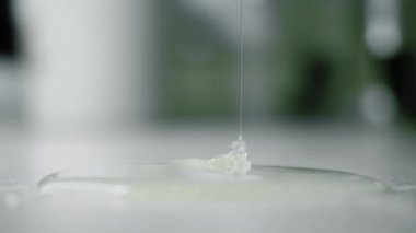 Kalın sıvı yapıştırıcı yavaşça yukarıdan ince akıntıya dökülür ve yüzeyde yayılır.