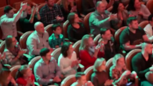 Espectadores brumosos irreconocibles en la sala aplauden intensamente mientras están sentados en el teatro — Vídeos de Stock