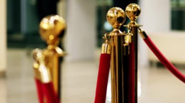 Velvet red luxury ropes closed at valuable exhibit in museum or vip zone concert