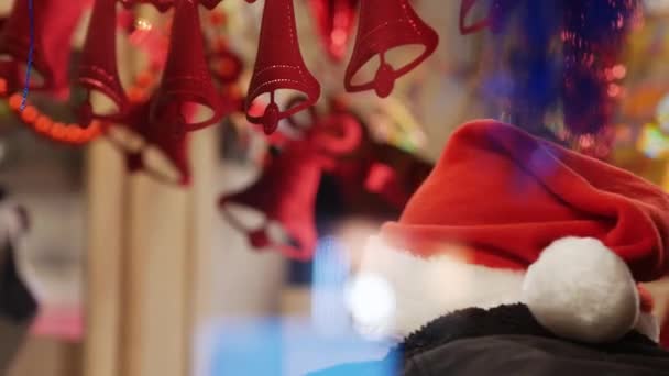 Unrecognizable man in a red New Year cap. Tinsel and silver red bells garland — Stockvideo