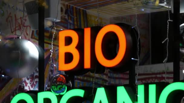 Bright glowing color sign on shop window in evening BIO ORGANIC NATURAL BEAUTY — Stockvideo