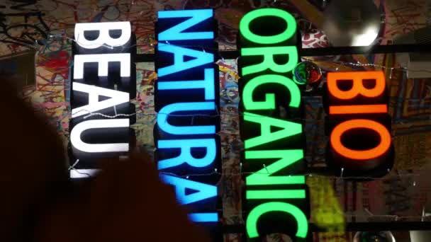 Bright glowing color sign on shop window in evening BIO ORGANIC NATURAL BEAUTY — Stock Video