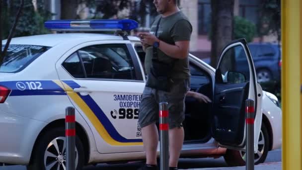 Agenten in uniform gewapend met machinegeweren stappen in de politieauto en rijden weg — Stockvideo