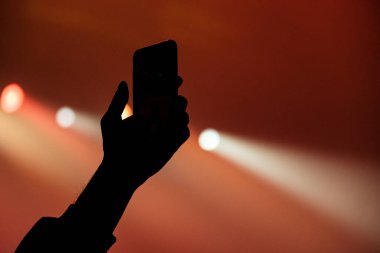bir el ile bir smartphone bir konserde silüeti.