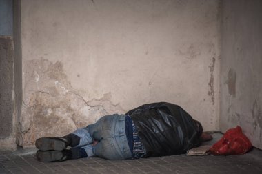 VILNIUS, LITHUANIA - 6 Ekim 2021: Evsiz bir adam geçitte uyuyor.