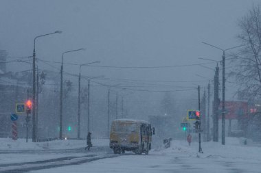ARKHANGELSK, RUSSIA - HAZİRAN 05 2022: Sarı bir otobüs kar altında kentten geçiyor.