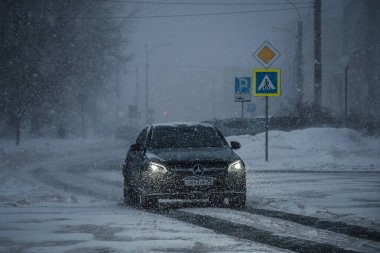 ARKHANGELSK, RUSSIA - HAZİRAN 05 2022: Kar altında bir araba şehrin içinden geçiyor