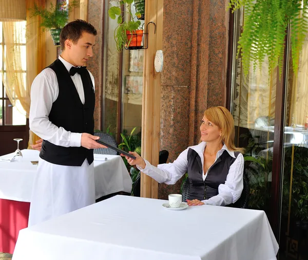 bir restoranda fatura ödeme, genç ve çekici bir kadın