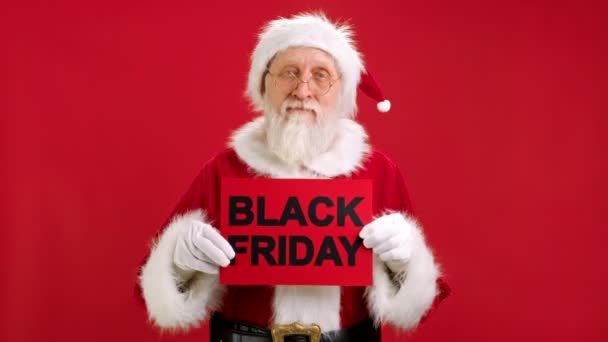 Santa Claus Holding Banner met opschrift BLACK FRIDAY kijkt naar hem en schudt zijn hoofd in ongenoegen en toont Vinger Down Gesture met zijn hand. Niet blij met de kerstman Kortingen te koop. — Stockvideo