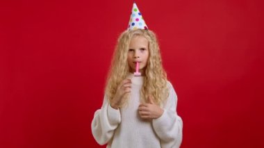 Parti dolandırıcılığı boynuzunda kadın portresi, doğum gününü kutlamak, mutluluğu ifade etmek, eğlenmek, gündelik tarzda uzun kollu gömlek giymek. Kırmızı arkaplanda kapalı stüdyo çekimleri.