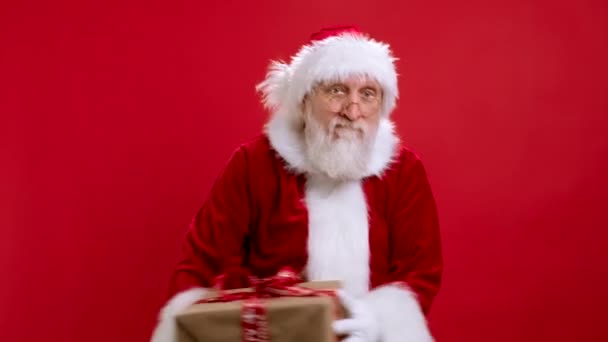 Black Friday Noël Vente Concept, Cyber Vente, Big Remises. Père Noël en costume de Noël attrape boîte cadeau et sourit heureusement à la caméra sur fond rouge. Père Noël joyeux reçoit un cadeau. — Video