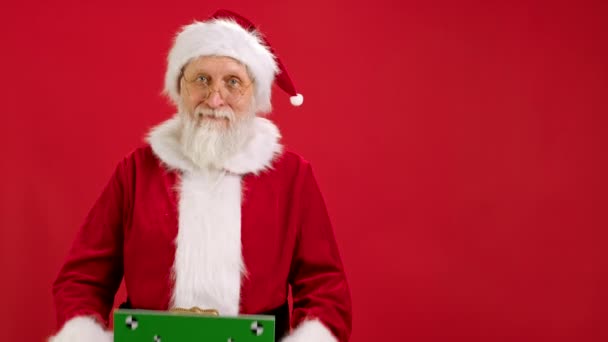 "Веселий Санта Клаус" тримає "Зелений екран" як контрольні точки для копіювального простору. Чорний зелений екран. Показує пристосований жест з простором для тексту або рекламування на червоному фоні. — стокове відео