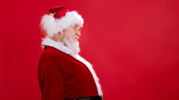 Le Père Noël en costume de Noël regarde dans l'appareil photo et soulève signe noir pour dessiner avec de la craie, blanc pour une bannière publicitaire, vente de publicité le vendredi noir, cases à cocher Mockup votre texte. — Video