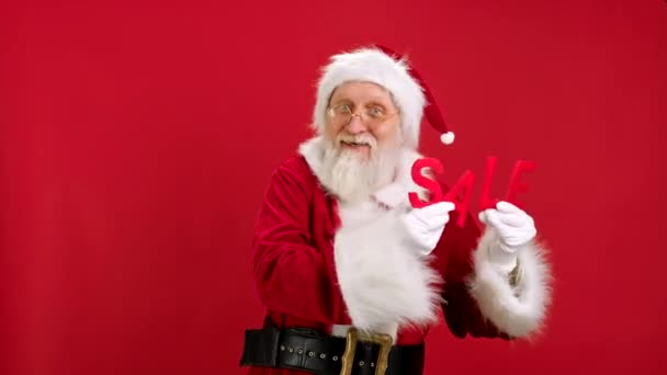 Alegre Santa Claus es feliz con grandes descuentos en Navidad Viernes Negro bailando sosteniendo letras rojas con la palabra VENTA en Red Studio fondo. Descuento venta, Viernes Negro, Cyber Monday. — Vídeos de Stock
