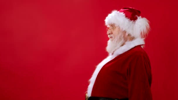 Santa Claus en traje de Navidad mira a la cámara y levanta el cartel negro para dibujar con tiza, en blanco para un anuncio publicitario, venta de publicidad el viernes negro, casillas de verificación de burla de su texto. — Vídeo de stock