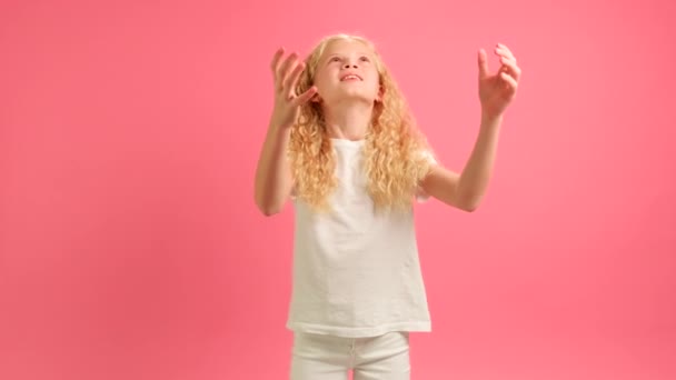 Blond Caucasian girl happy dancing holding in his hands message saying I LOVE YOU from an inflatable gel ball. Girl confesses his love on Mothers Day holding inscription I LOVE YOU on pink background. — стокове відео