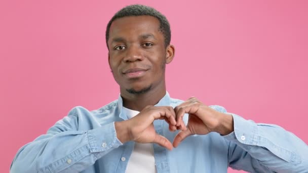 Portrait happy young Afro american man volunteer showing hands sign heart shape looking at camera. Healthy heart health life insurance, love and charity, voluntary social work, organ donation concept. — стоковое видео