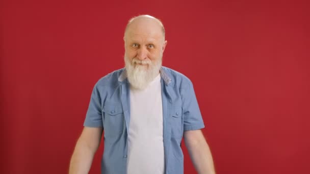 Retrato alegre sonriente abuelo barbudo, sosteniendo en sus manos letras rojas del mundo VENTA bailando y alegremente sonriente, saludando palabra venta sobre fondo rojo estudio. Feliz viernes negro ventas. — Vídeos de Stock