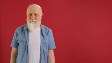 Yaşlı Sakallı Adam 'ın imzası indirimli -60 dolar indirimli, Boş Alan' da parmağını gösteren, Kamerada İndirime Bakan ve Kırmızı Arkaplanda Gülümseyen. Kara Cuma 'da indirimli satışlar.