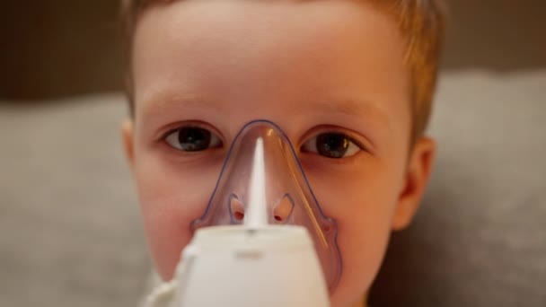 Portrait Baby has respiratory infection or bronchitis and is breathing heavily. Treatment pneumonia with nebulizer. Blond caucasian child with asthma problems does inhalation with mask on his face. — Vídeos de Stock
