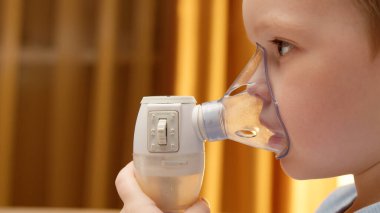 Treatment pneumonia with nebulizer. Portrait Baby has respiratory infection or bronchitis and is breathing heavily. Blond caucasian child with asthma problems does inhalation with mask on his face.