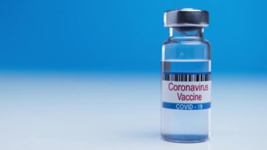Victory over a worldwide epidemic nCoV. Found a cure for virus sars-cov-2. Medical ampoule with coronavirus covid-19 vaccine on blue background. 