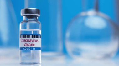 Close-up ampoules with COVID-19 coronavirus vaccine. Bottle of vaccine against SARS-CoV-2 virus on background laboratory table. Drugs against nCoV pandemic. Concept defeating coronavirus