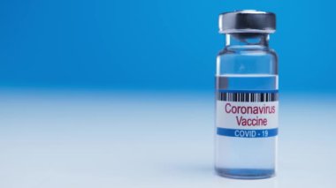 Medical ampoule with coronavirus covid-19 vaccine on blue background. Victory over a worldwide epidemic nCoV. Found a cure for virus sars-cov-2.