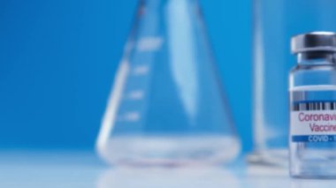 Close-up ampoules with COVID-19 coronavirus vaccine. Bottle of vaccine against SARS-CoV-2 virus on background laboratory table. Drugs against nCoV pandemic. Concept defeating coronavirus