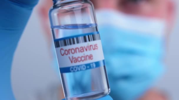 Doctor microbiologist close-up shows in a bottle a drug from the world epidemic of coronavirus Covid-19. Pharmacology drugs against pandemic nCoV. Concept victory over coronavirus. — Stockvideo