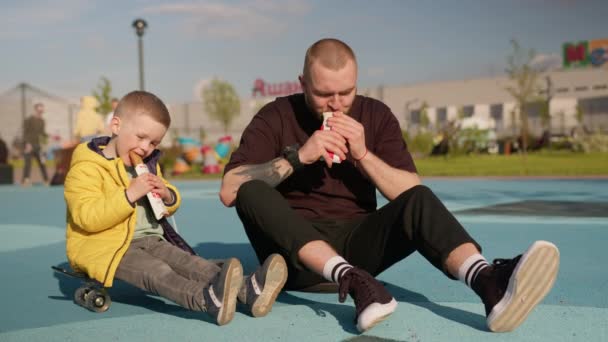 Father Son Spend Time Together Eating Food Sitting Asphalt Park — Stock videók